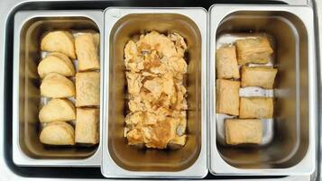 Three metal trays with food items.