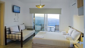 Une chambre d’hôtel avec un lit, un petit bureau, une chaise, une télévision et un balcon avec vue.