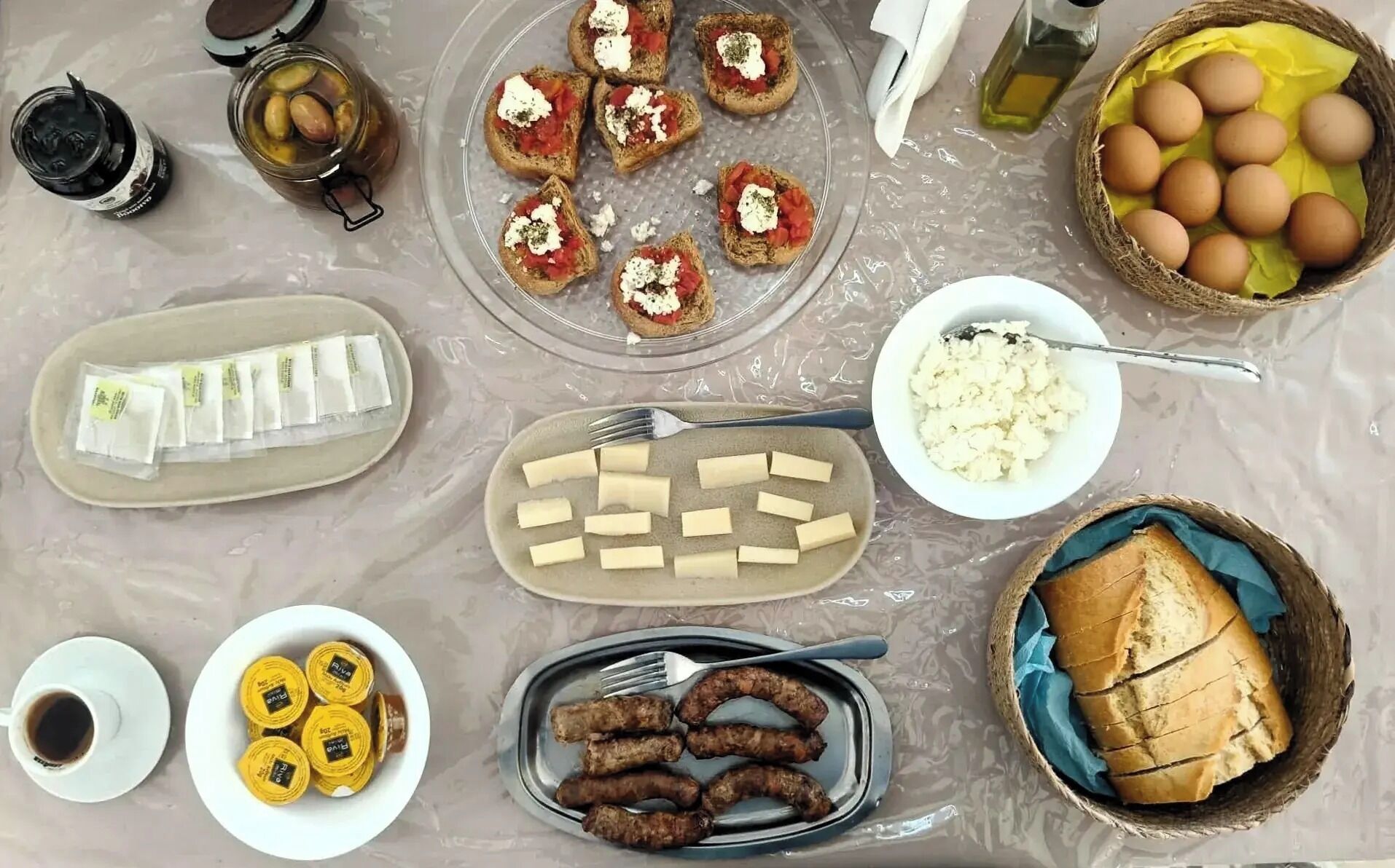 Une table garnie de divers aliments, notamment du pain, du fromage et des saucisses.