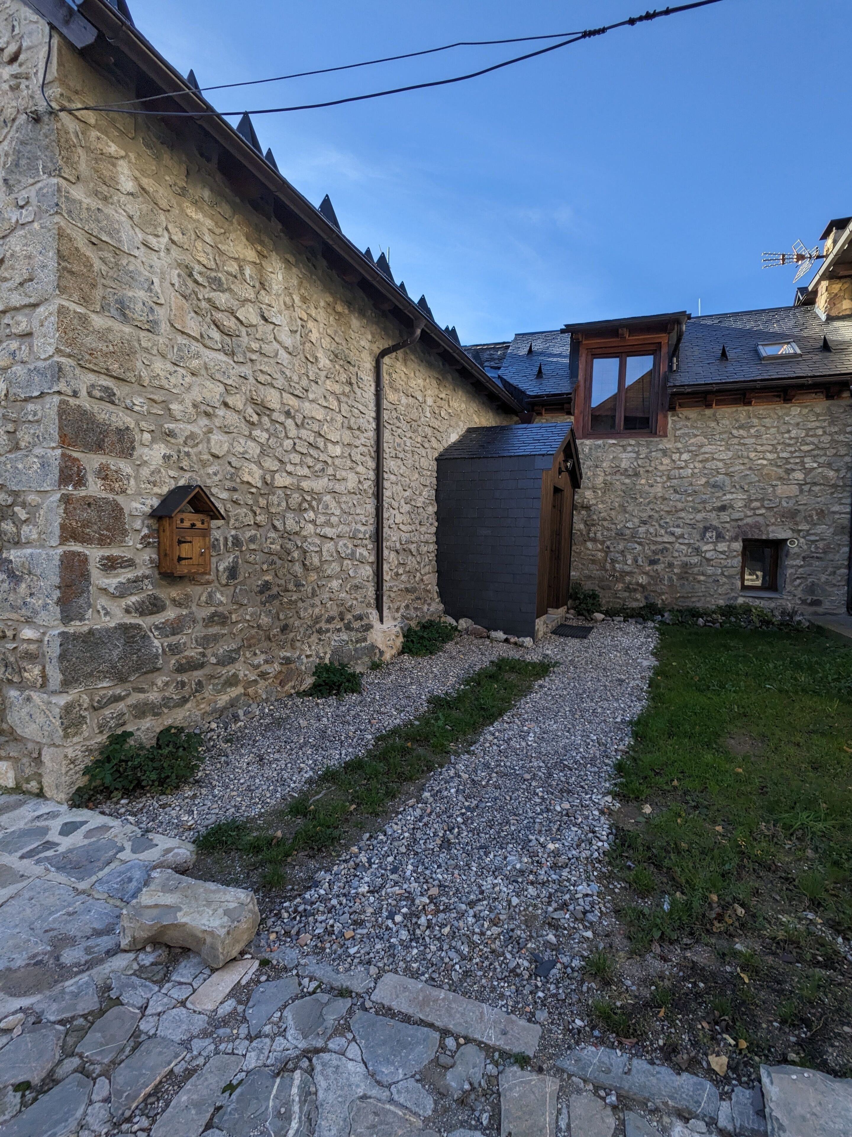 A stone building with a gravel path and a wooden door.