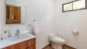 A bathroom with a wooden vanity, a toilet, and a window. - Cozy beach house, partial view, 2 mn walk to beach (Guanacaste Province)