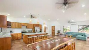 A spacious kitchen with wooden cabinets and a large island. - Cozy beach house, partial view, 2 mn walk to beach (Guanacaste Province)