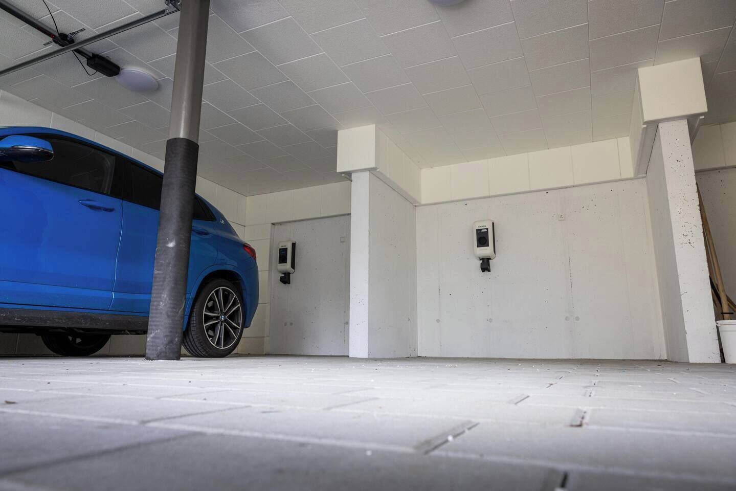 A parking garage with a blue car parked inside.