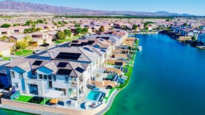 A residential area with houses along a river, featuring a large house with a swimming pool and solar panels. - Lakeside Lottery/Game Room/EV (Indio)