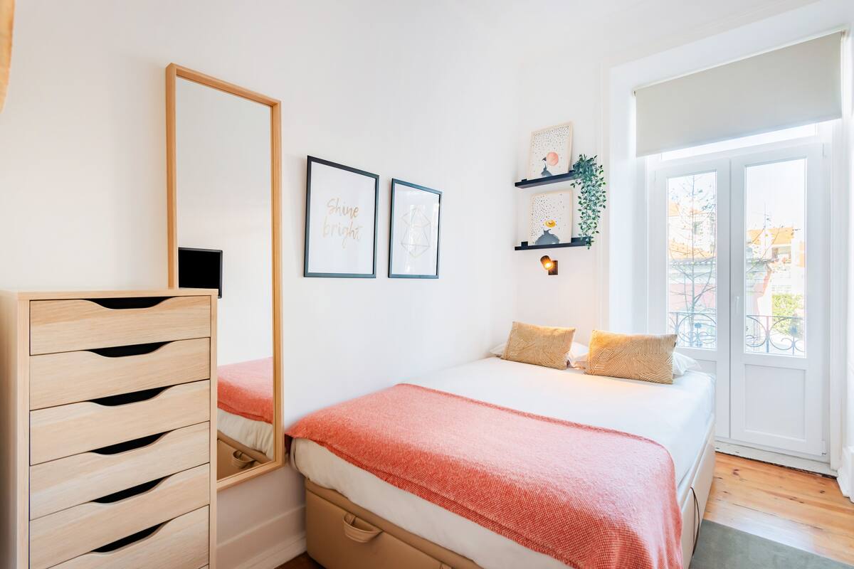 Ein Schlafzimmer mit Bett, Schminktisch, Spiegel und Fenster mit Blick.