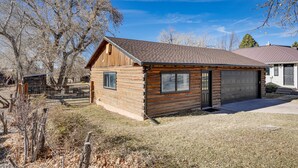 A log cabin with a garage, surrounded by trees and a clear sky. - Cozy Parowan Studio: 12 Mi to Brian Head Resort! (Parowan)