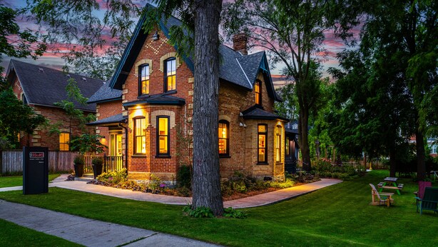 A brick house with a well-maintained lawn and a picnic table.