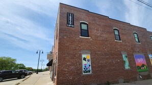 Un bâtiment en briques avec une enseigne indiquant « 1890 LOFTS » et une fresque murale sur le côté.