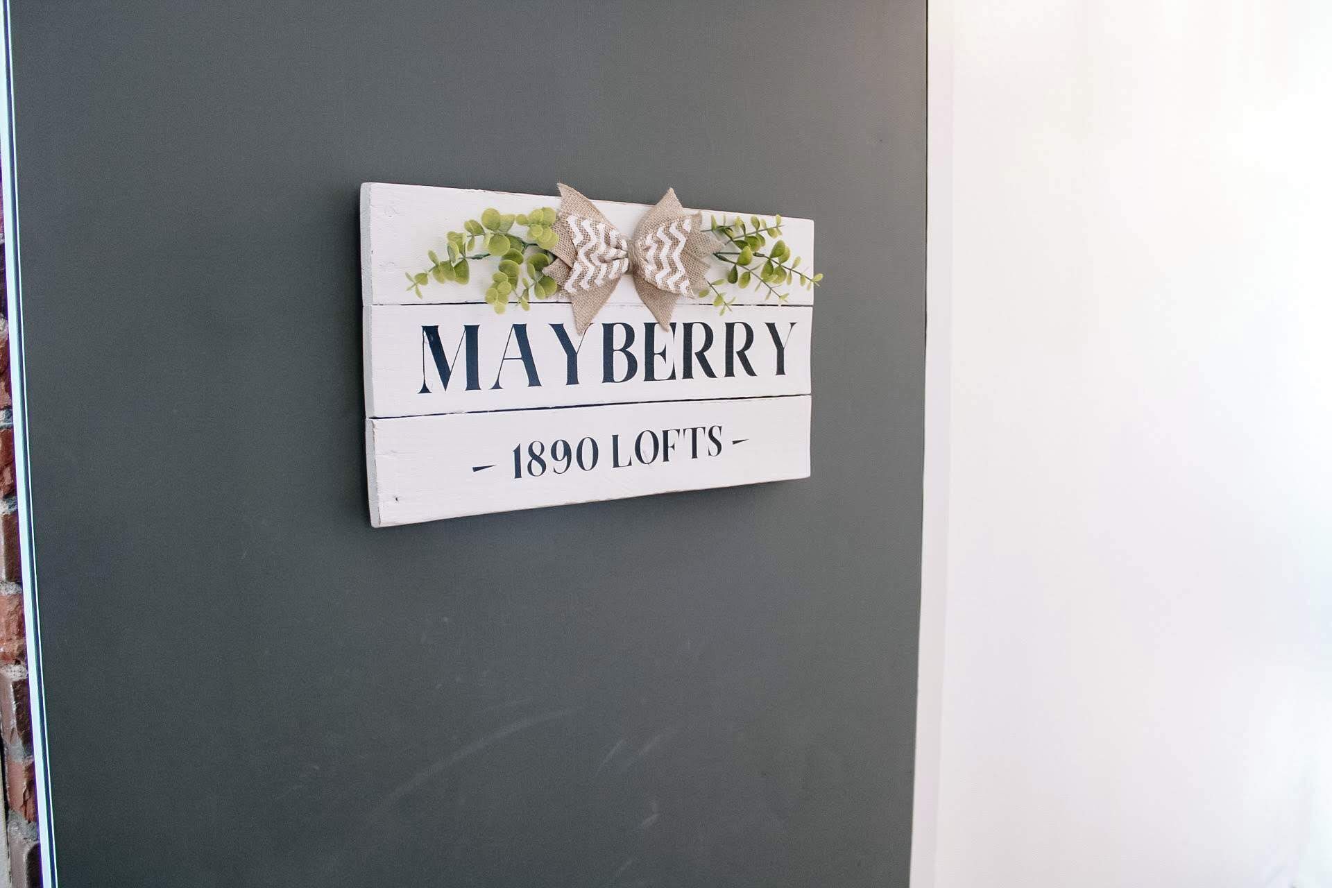 Une enseigne sur un mur, portant l’inscription « MAYBERRY – LOFTS 1890 ».