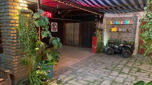Entrada de un edificio con un sendero adoquinado, un muro de ladrillo y una motocicleta estacionada afuera.