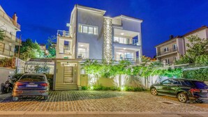 A modern two-story building with a central tower, a gated entrance, and a paved driveway. - Holiday apartment with shared-use pool (Crikvenica)