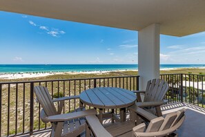 A balcony with a table and chairs overlooking a beach. - NEWLY RENOVATED 3 Bedroom CORNER unit on the 4th Floor With Gulf Views! (Orange Beach)