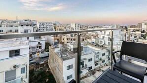 A balcony with a view of a cityscape, a chair, and the logo "360 ESTATES". - POOL access and a beautiful 1BR APT in Swieqi (Is-Swieqi)