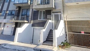 A multi-story residential building with balconies, a gated entrance, and a staircase leading to the entrance. - A fully equipped APT with private balcony & Pool (Is-Swieqi)