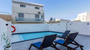A rooftop pool area with lounge chairs and a lifebuoy. - Spacious, fully equipped 1BR maisonette with Pool (Is-Swieqi)