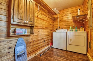 Laundry room with washer and dryer, ironing board, and storage.