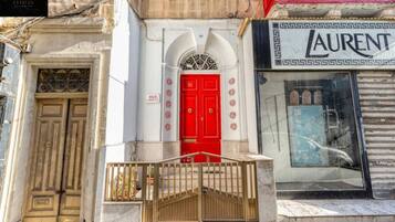 Facciata di un edificio con una porta rossa, un'insegna per '360 Estates' e un negozio 'Laurent'.