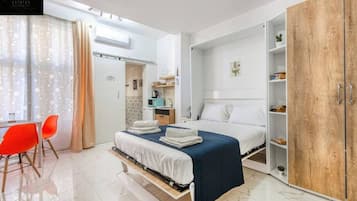 Una camera d'albergo moderna con un letto, una scrivania e un armadio.