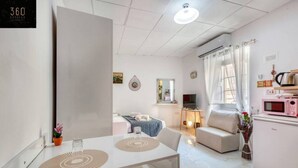 A modern, well-lit living room with a dining area, a kitchenette, and a bedroom. - Urban studio room in Sliema Ferries with Views (Tas-Sliema)