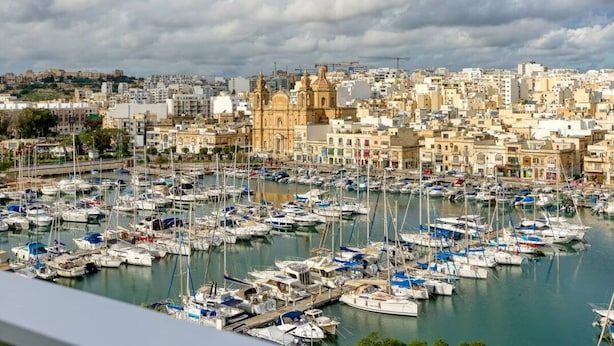 A marina filled with boats, surrounded by historic buildings and a cityscape in the background. - Beautiful seafront home with private balcony & BBQ (Tal-Pietà)