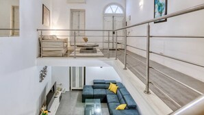A modern interior with a staircase, a sofa set, and a dining area. - An amazing 2BR home with a special private rooftop (Tas-Sliema)