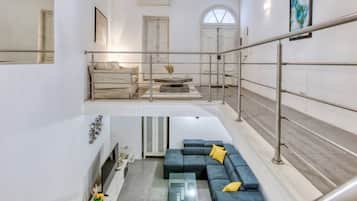 Un interno moderno con una scala, una zona divano e un'area pranzo.