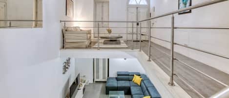 Een modern interieur met een trap, een zithoek en een eethoek.