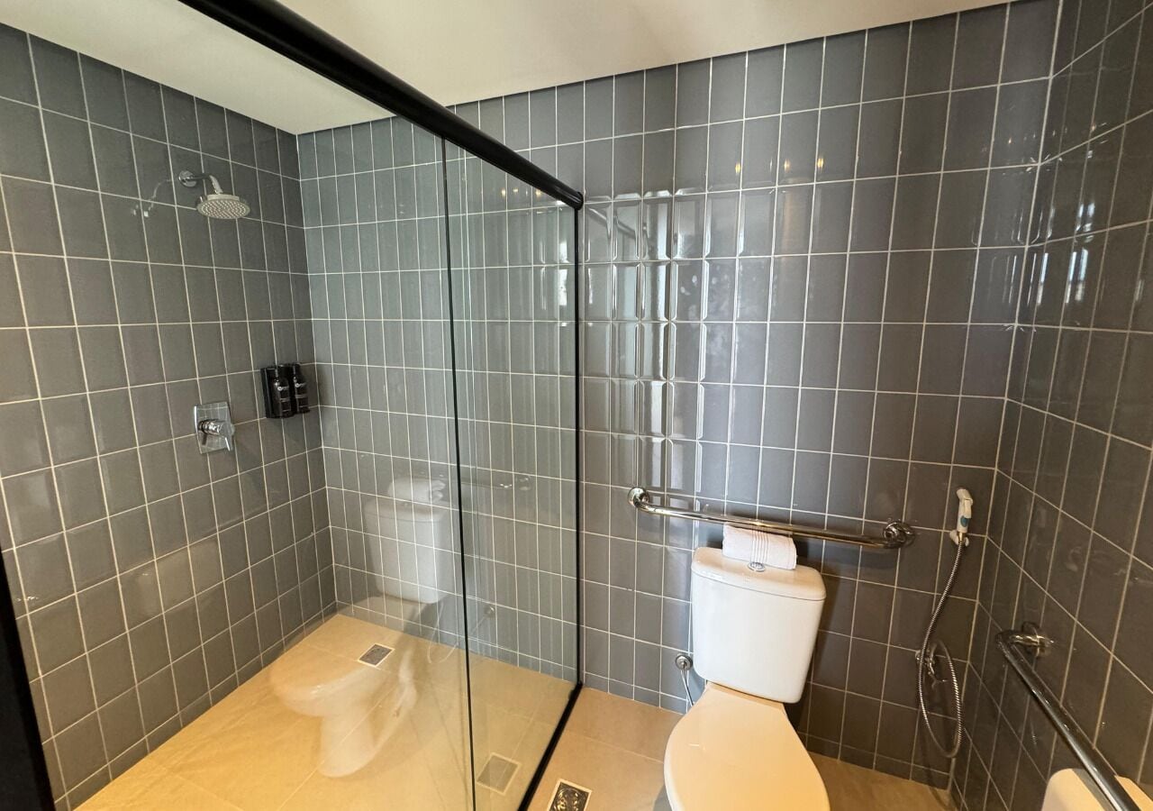 Un baño moderno con ducha envuelta en vidrio, un inodoro y un lavamanos.