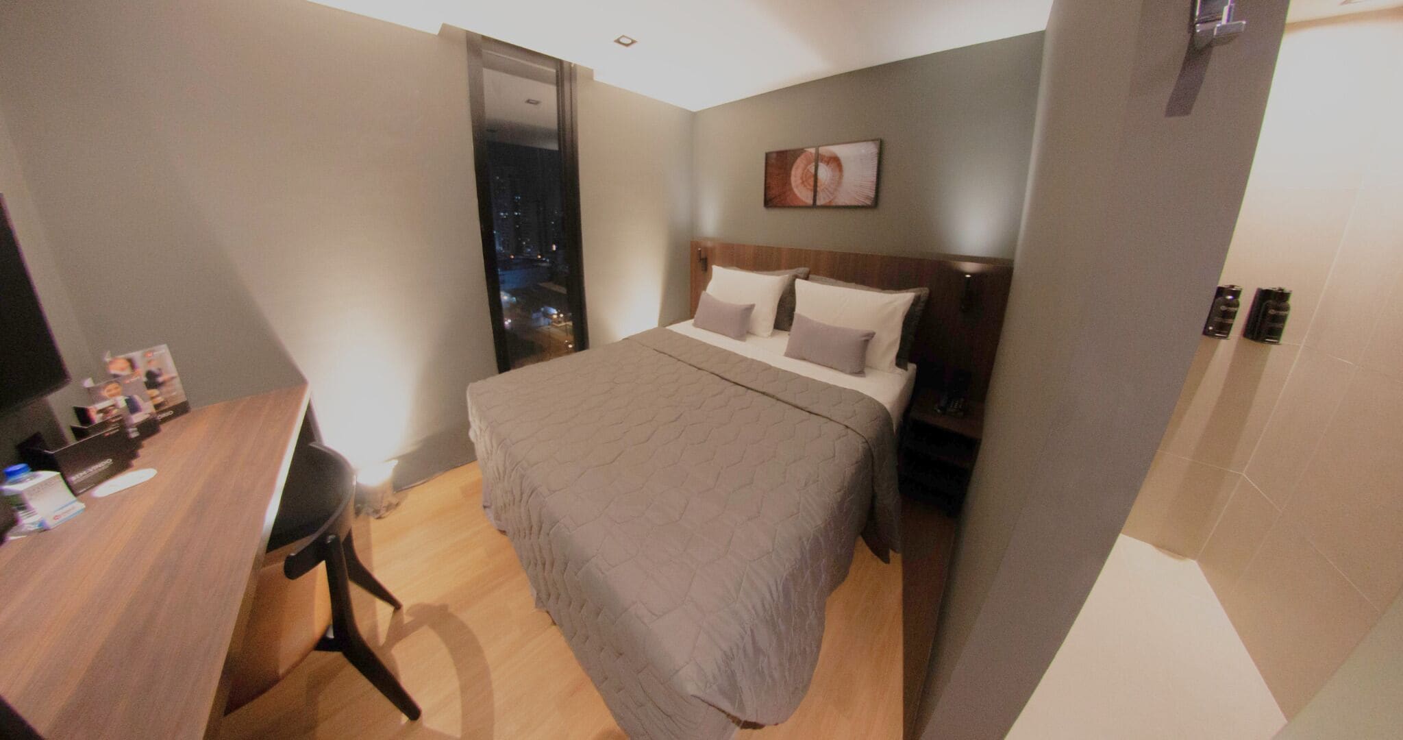 Una habitación de hotel con una cama, un escritorio y una silla.