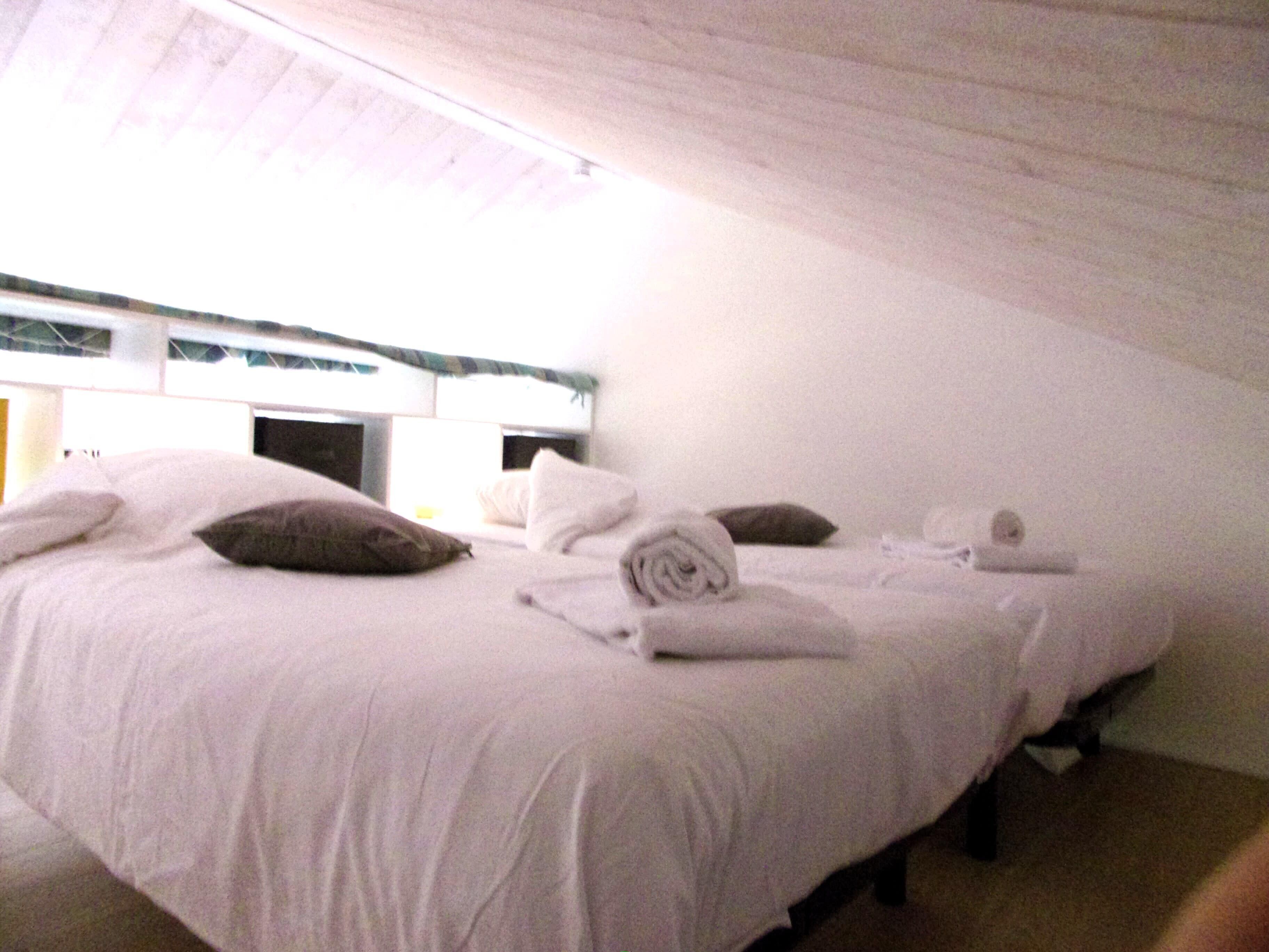 Habitación individual con techo alto y tejado inclinado.