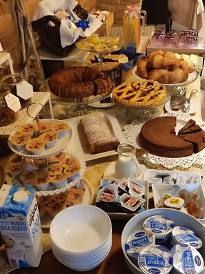 A buffet table with various desserts, pastries, and dairy products. - casa grimaldi  (Matelica)