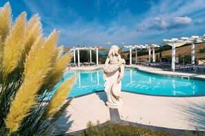 A statue by a pool with pergolas and seating areas. - casa grimaldi  (Matelica)