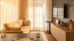 Una sala de estar moderna con un sofá, una mesa de centro y un televisor montado en la pared.