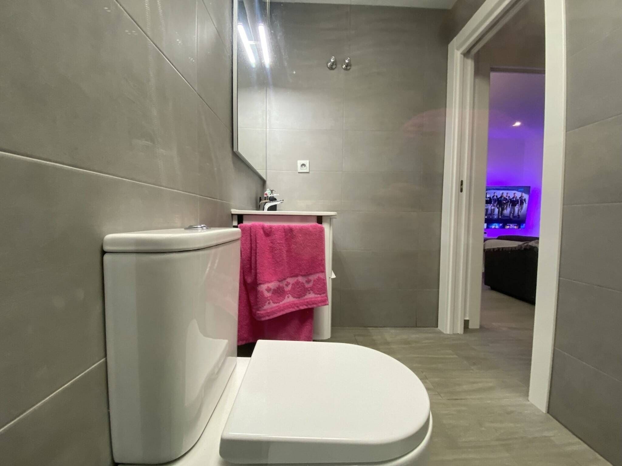 A modern bathroom with a toilet, sink, and shower.