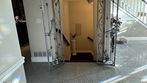 A staircase with a metal railing and a decorative archway leading to a landing. - Idaho Falls 6bed4bath Exquisite Home (Idaho Falls)