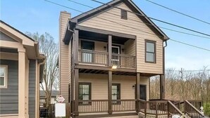 A two-story house with a balcony on the upper floor, a front porch, and a visible garage door. - Downtown Atlanta Anchor (Atlanta)
