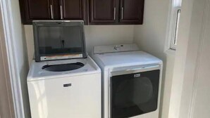 A compact laundry area with a washing machine and dryer. - Downtown Atlanta Anchor (Atlanta)
