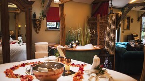 A room with a bed, a mirror, a table with a bowl, and a window with red curtains. - Romantic Lodge on Edge of Nature Reserve (Colchester)