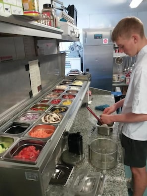 Una zona de cocina con estación de preparación de alimentos, que incluye diversos productos alimenticios y utensilios de cocina.