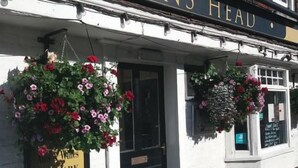 A building with a sign reading 'MAIDENS HEAD' and a hanging flower basket. - The Maidens Chambers (Canterbury)