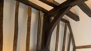 Ein Schlafzimmer mit einem rustikalen Holzkopfstück, einem Bett mit weißen Leinen und zwei Nachttischlampen.
