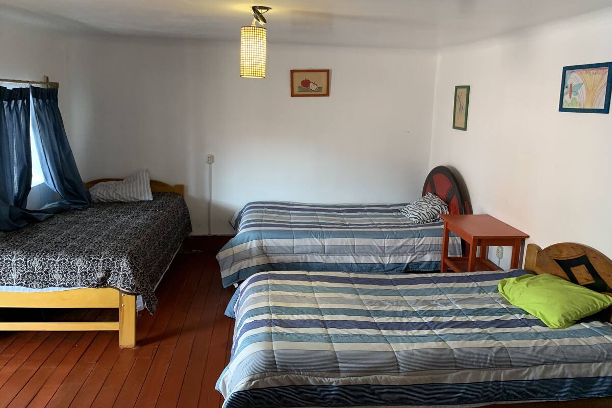 A room with two beds, a table, and a chair.