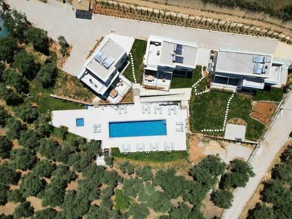 Une maison moderne dotée d’une piscine, d’un court de tennis et, au loin, d’un vignoble.
