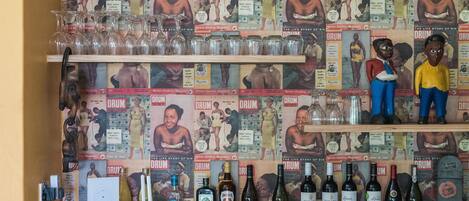 A bar with wooden cabinets and shelves displaying various bottles.
