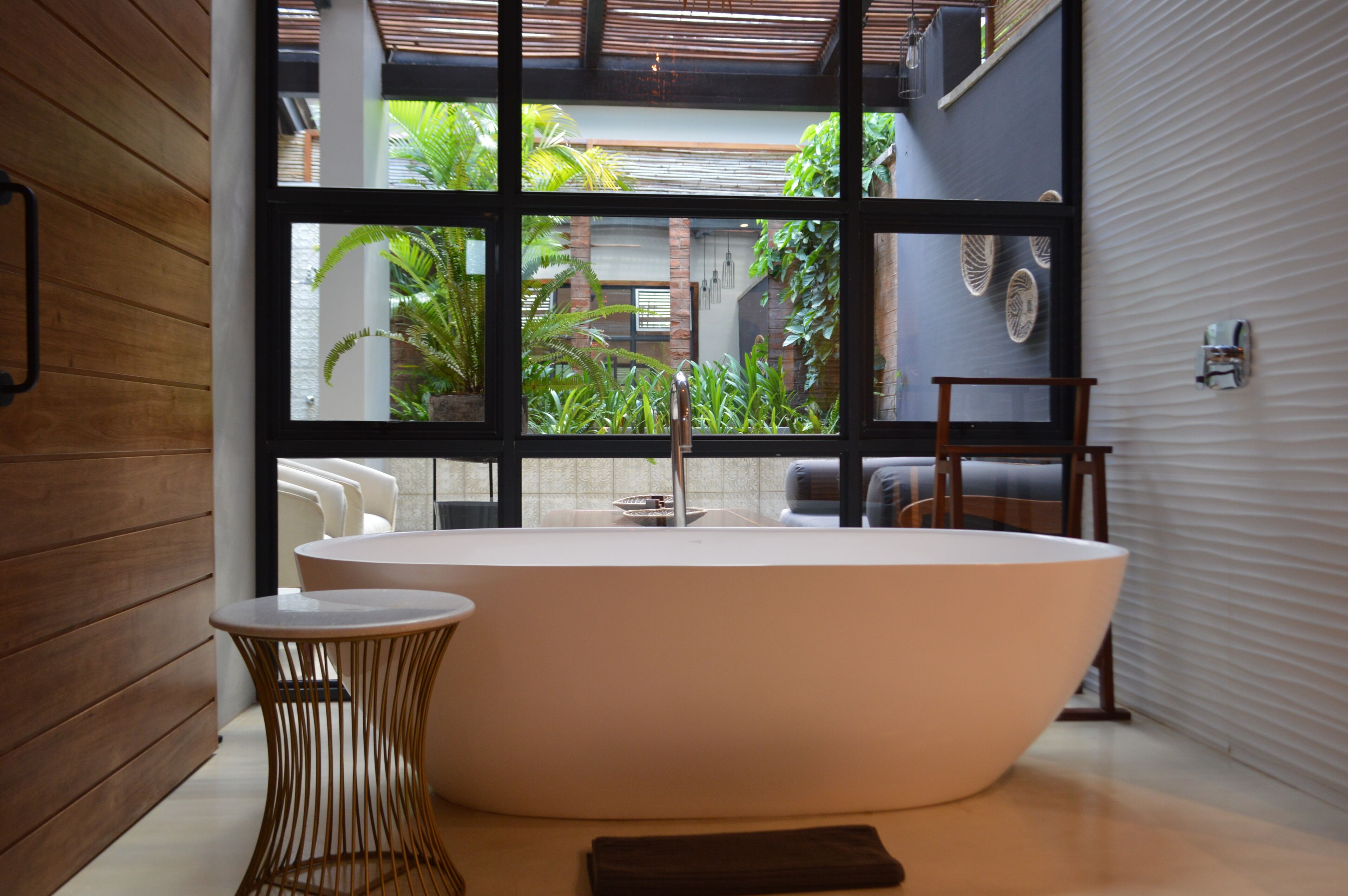 Une salle de bain moderne avec une baignoire sur pieds, une petite table ronde et une serviette.