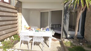 A patio with a table set for breakfast, including fruits, bread, and a coffee pot. - Waterfront studio in Penthièvre (Saint-Pierre-Quiberon)