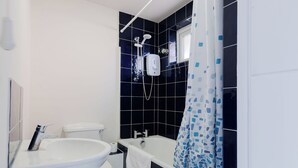 A modern bathroom with a toilet, sink, bathtub, and shower. - Spacious 3BDR Kennington Home with Private Garden (London)