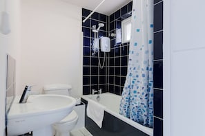 A modern bathroom with a toilet, sink, bathtub, and shower. - Spacious 3BDR Kennington Home with Private Garden (London)