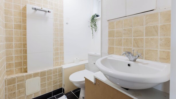 A bathroom with a toilet, sink, and shower. - Spacious 3BDR Kennington Home with Private Garden (London)
