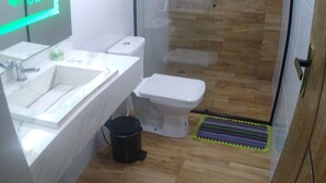 A modern bathroom with a glass-enclosed shower, a white sink, and a toilet. - Quarto Spotify (Taguatinga)